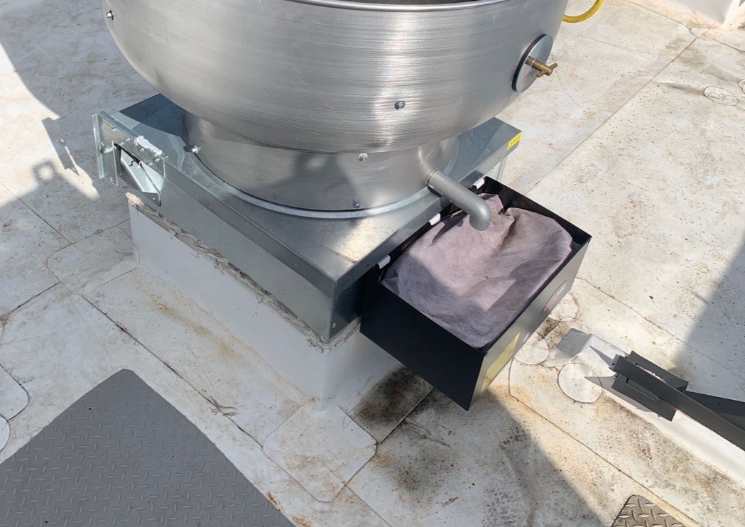 Current DRIPLOC grease containment system with replacement filter media on a rooftop exhaust fan